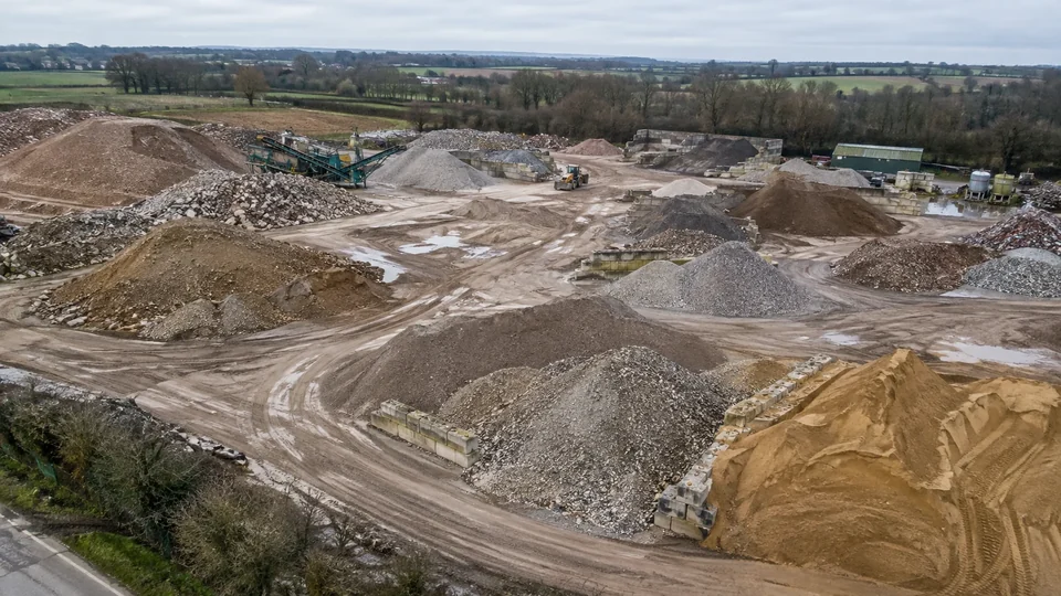 Aggregate stockpiles and vehicle tracks seen from above